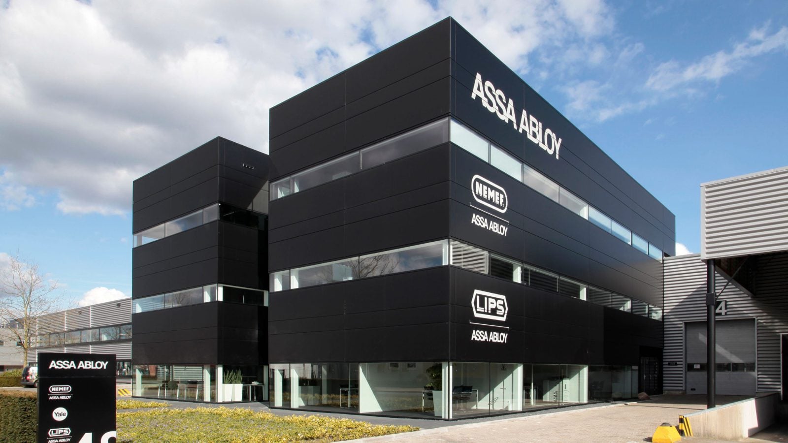 Kantoorpand van ASSA ABLOY met merklogo's op de zwarte gevel